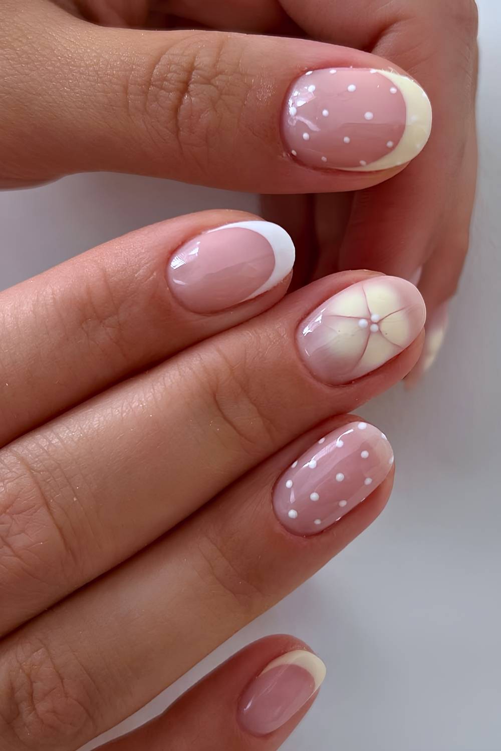 Weisse gelbe Naegel mit Blumen und Punkten