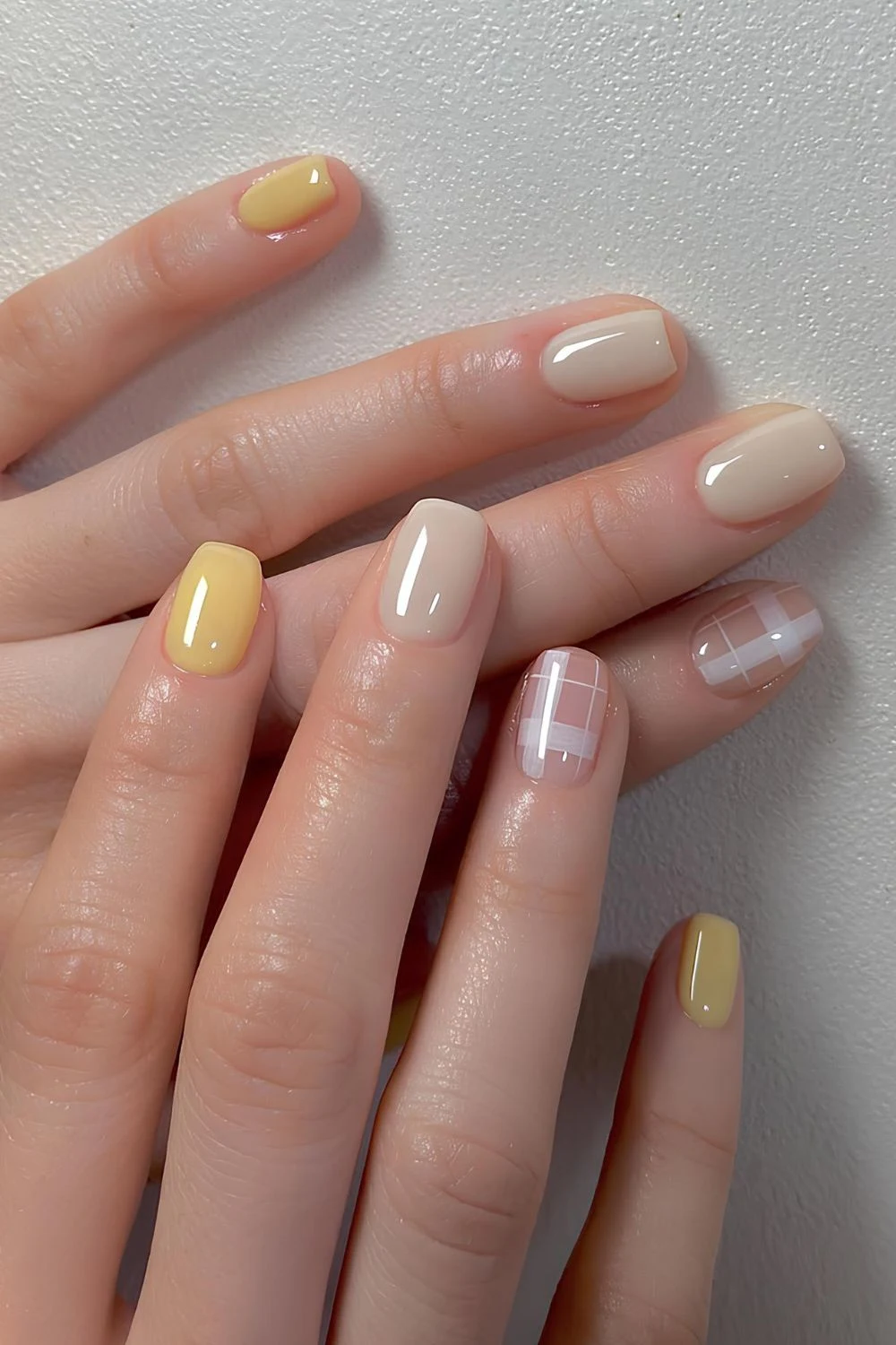 Gelbe Maniküre mit Karomuster-Akzent