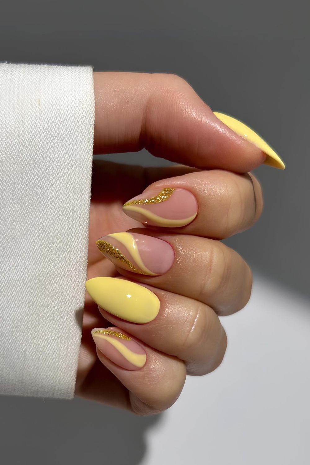Gelbe Nägel mit gelben und glitzernden Swirl-Details