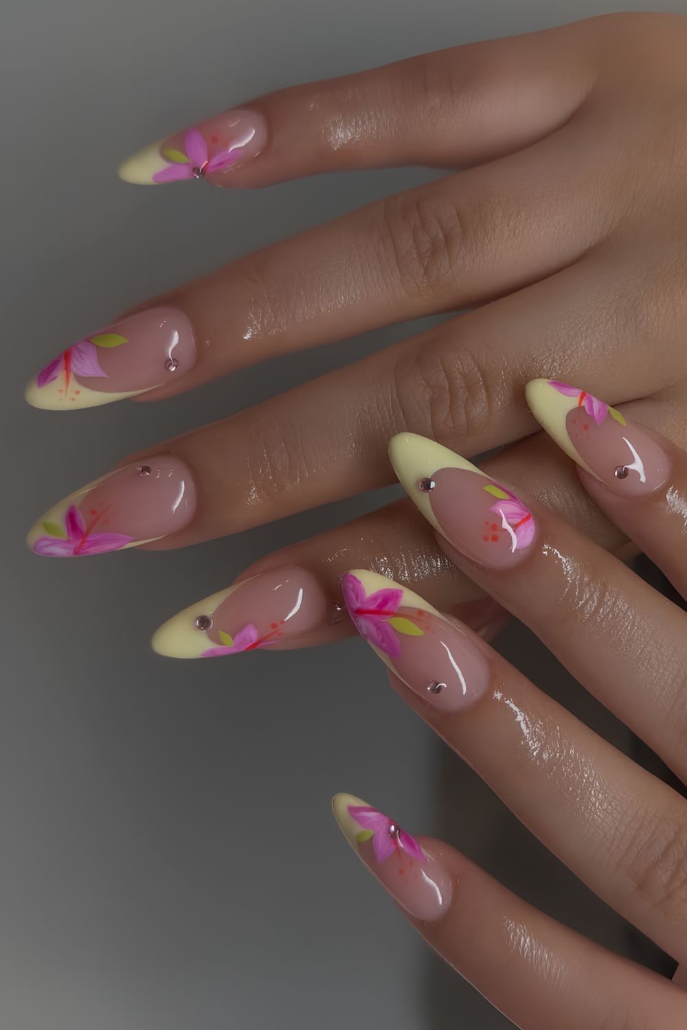 Buttergelbe French-Maniküre mit pinken Blüten