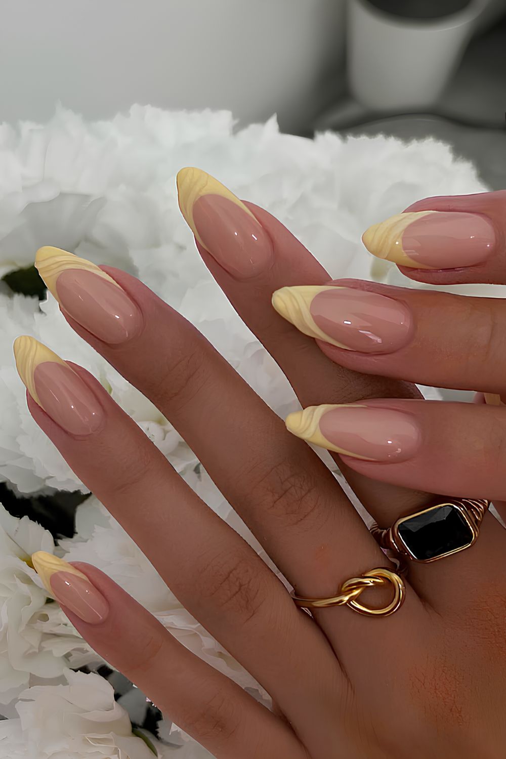 Gelbe French-Maniküre mit texturierten Swirls