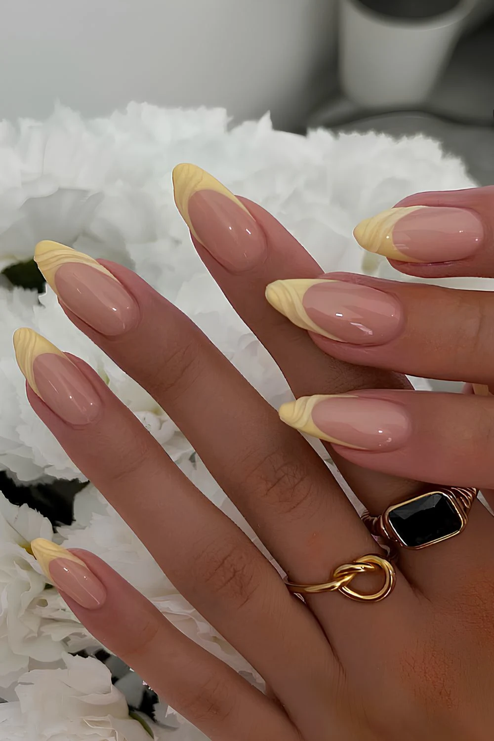 Gelbe French-Maniküre mit texturierten Swirls