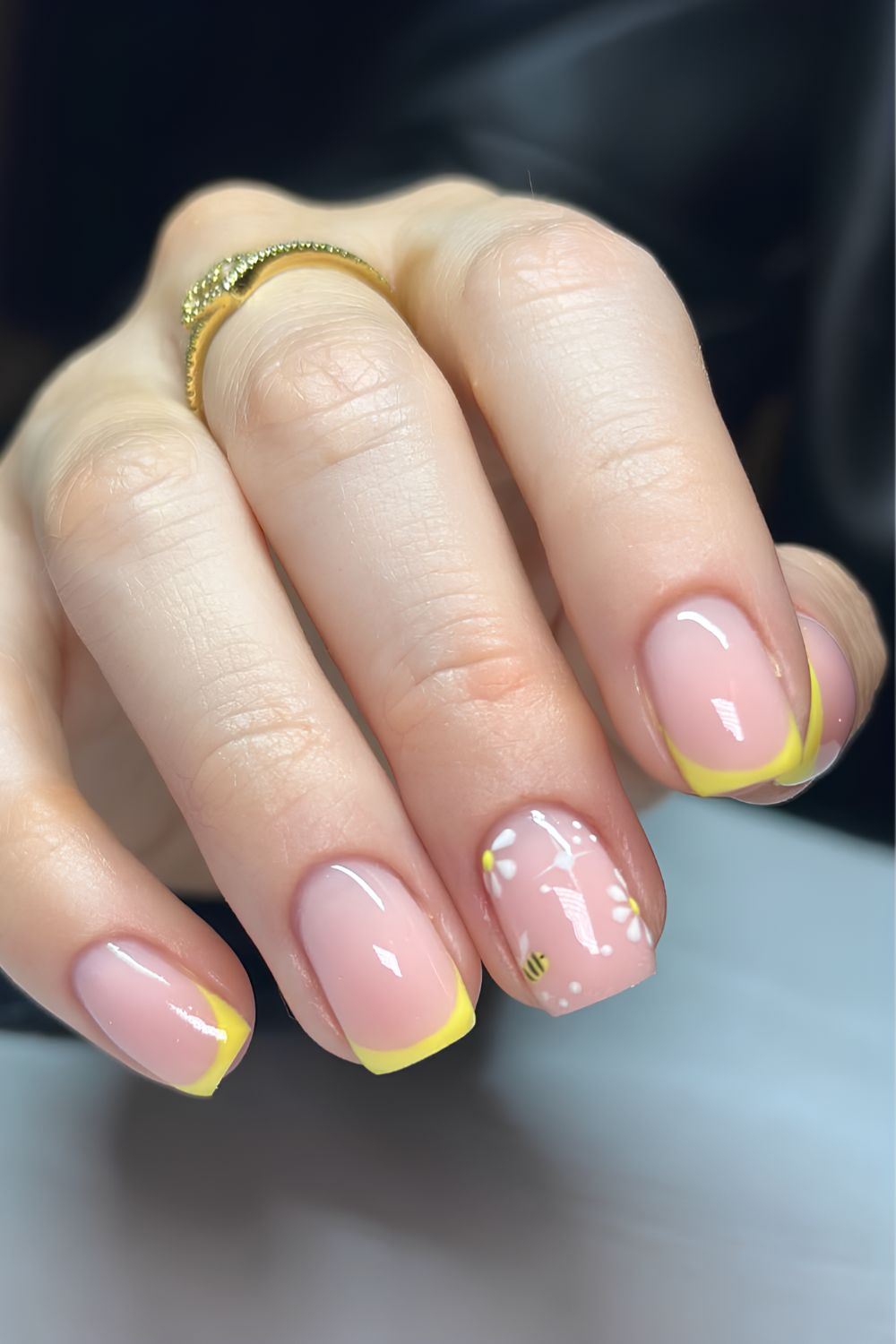 Gelbe French-Tip-Nägel mit Bienen- und Blumen-Design