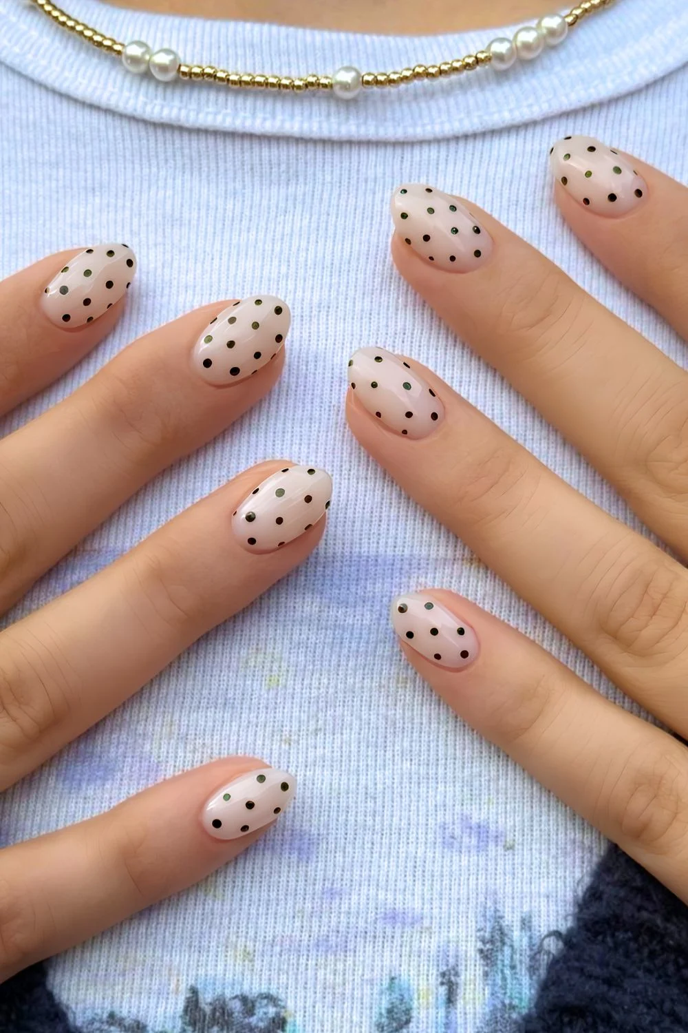 Milchig weiße Maniküre mit schwarzen Polka Dots