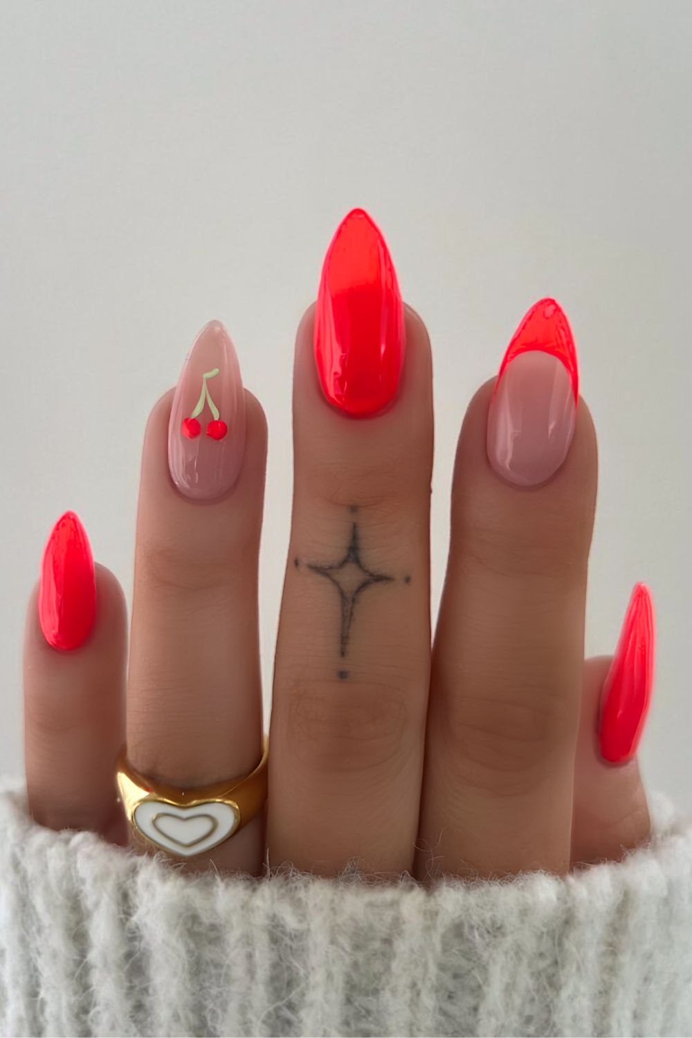 Neonkorallfarbene Maniküre mit Kirschakzent