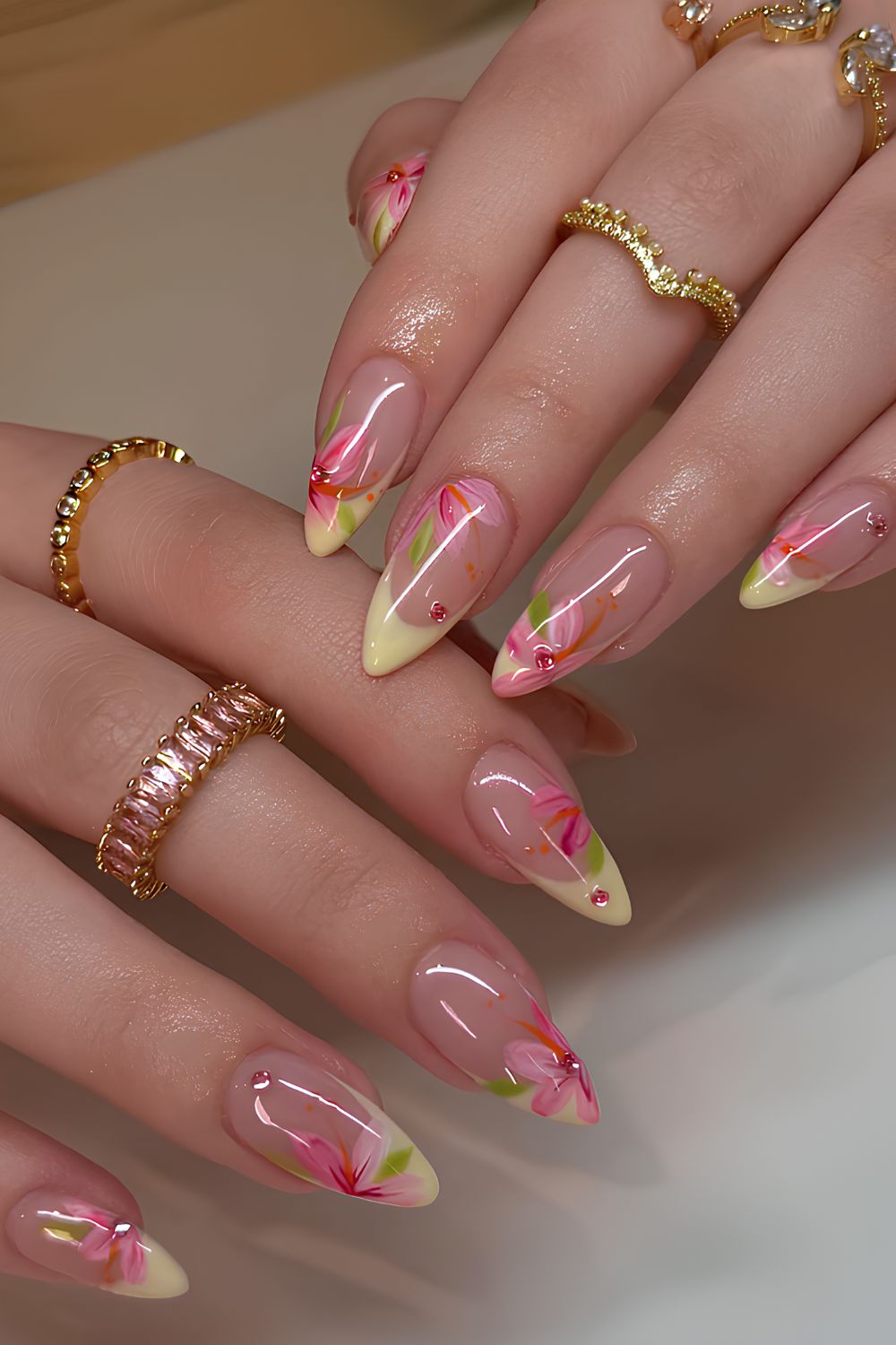 Pastellgelbe French-Maniküre mit rosa Blumen