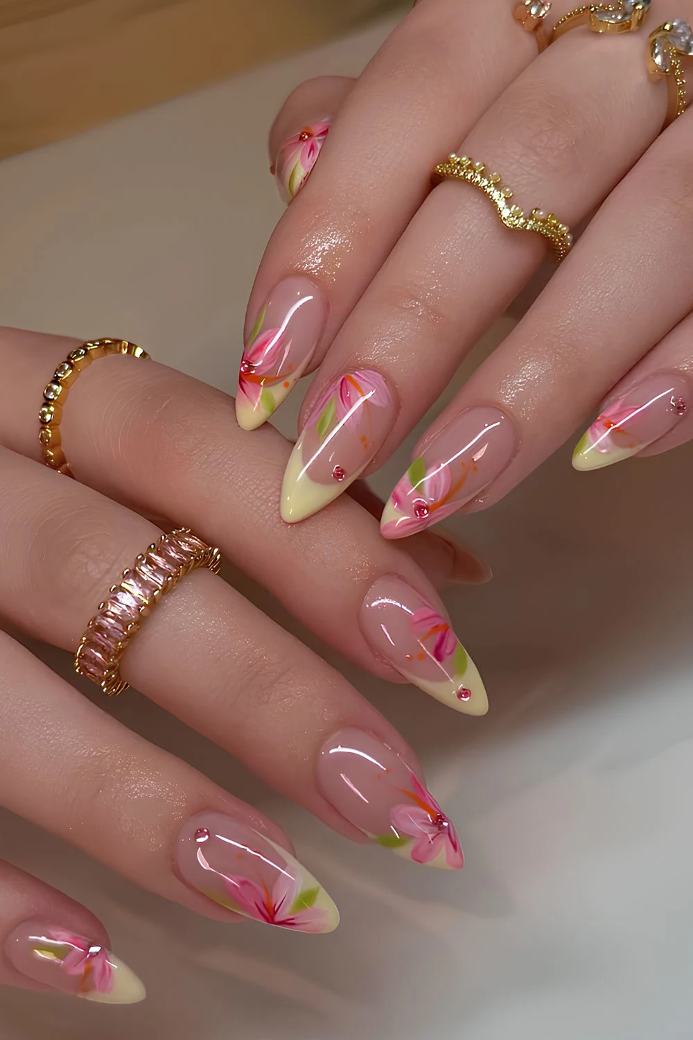 Pastellgelbe French-Maniküre mit rosa Blumen