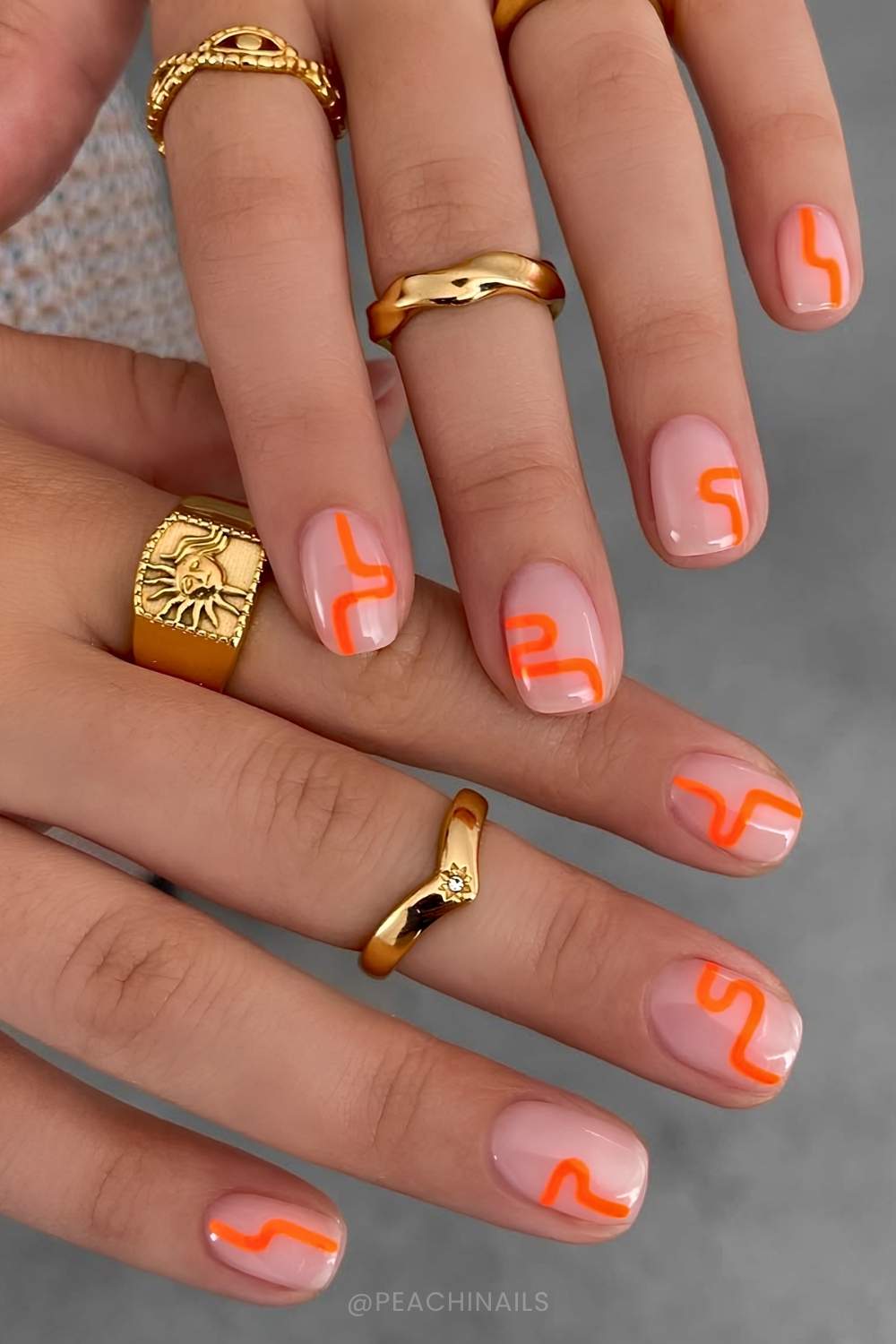 Sheere Naegel mit neonorangen Wellenlinien
