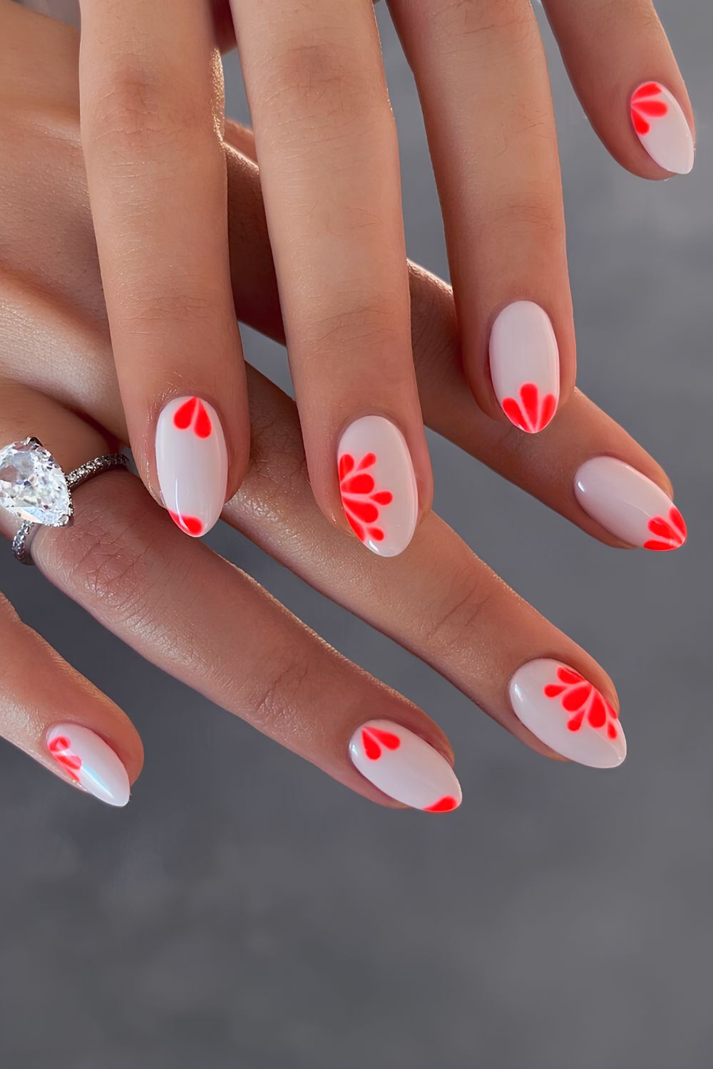 Weiße Maniküre mit neonkorallenfarbenen Blumen