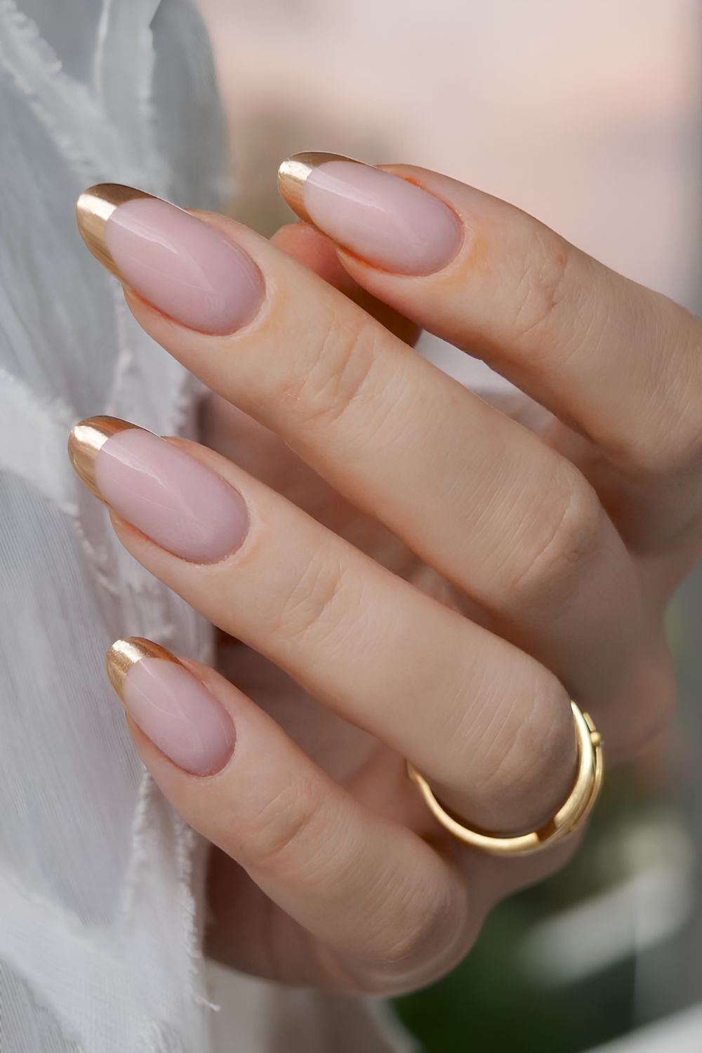 Gold-French-Tips auf milchig-rosa Basis