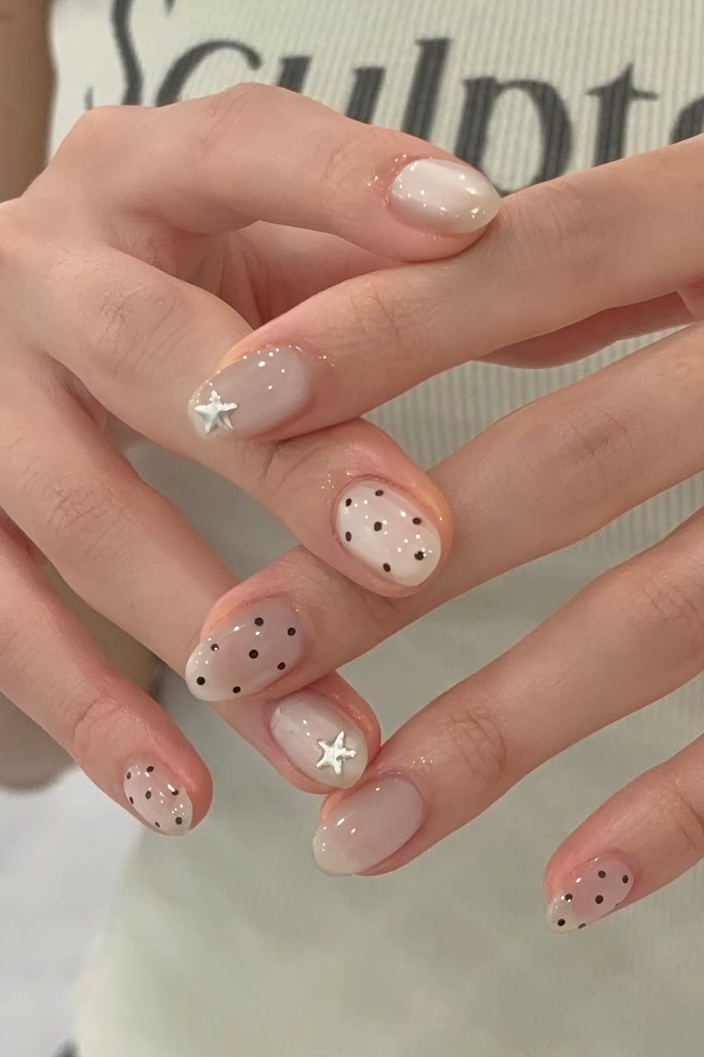 Neutrale Jelly-Nägel mit schwarzen Polka-Dots und silbernen Sternen