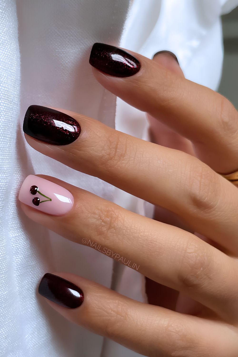 Schimmernde tiefrote Maniküre mit Kirsch-Nailart