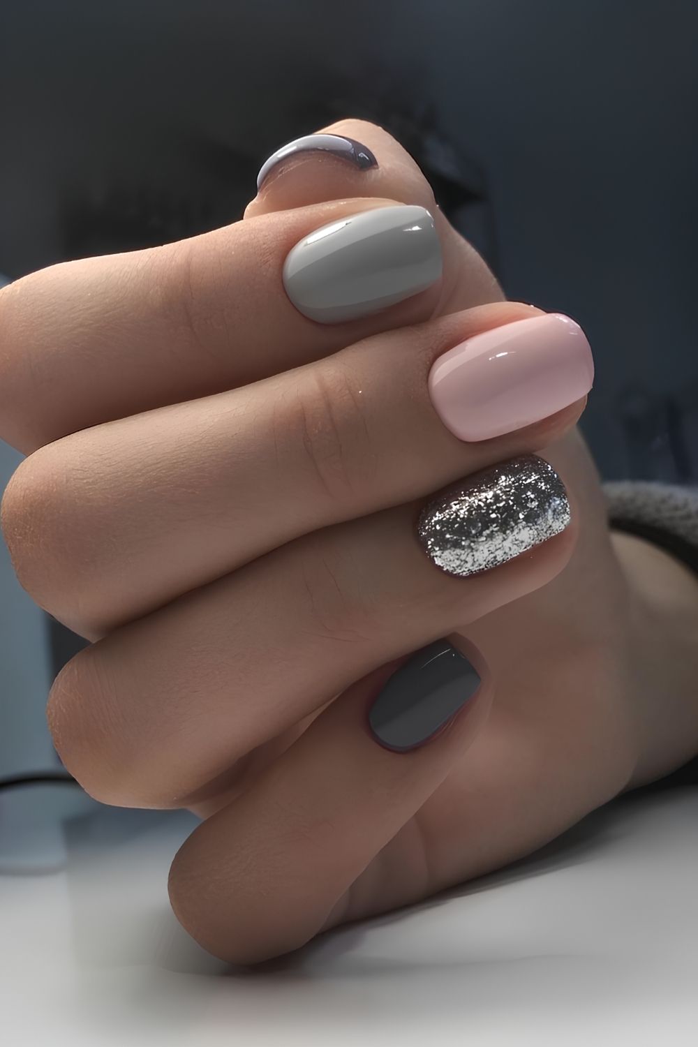 Graue Maniküre mit Pink und Glitzer-Details