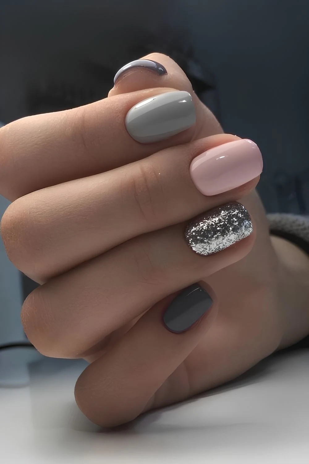 Graue Maniküre mit Pink und Glitzer-Details