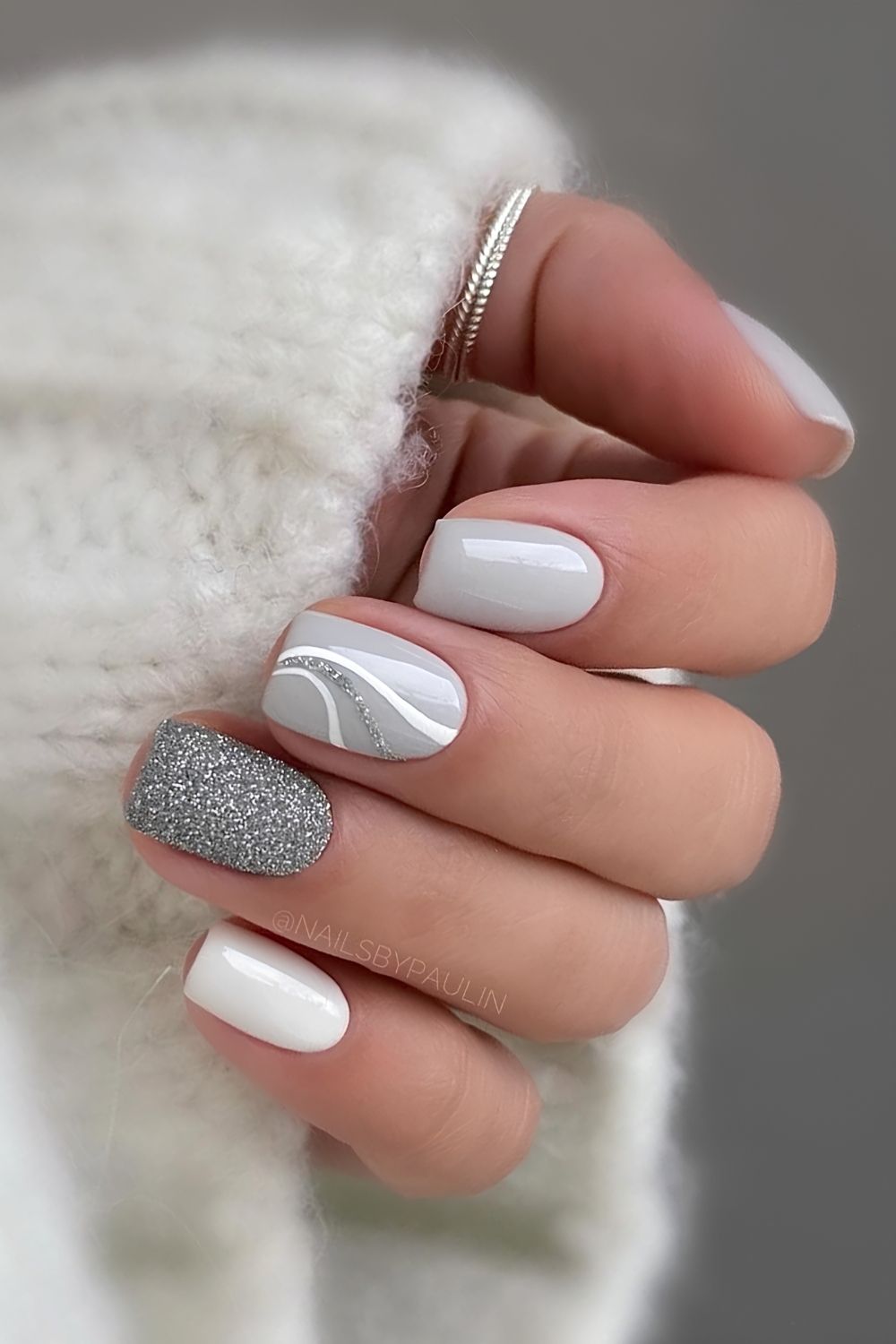 Helle graue Nägel mit Glitzer und Swirls