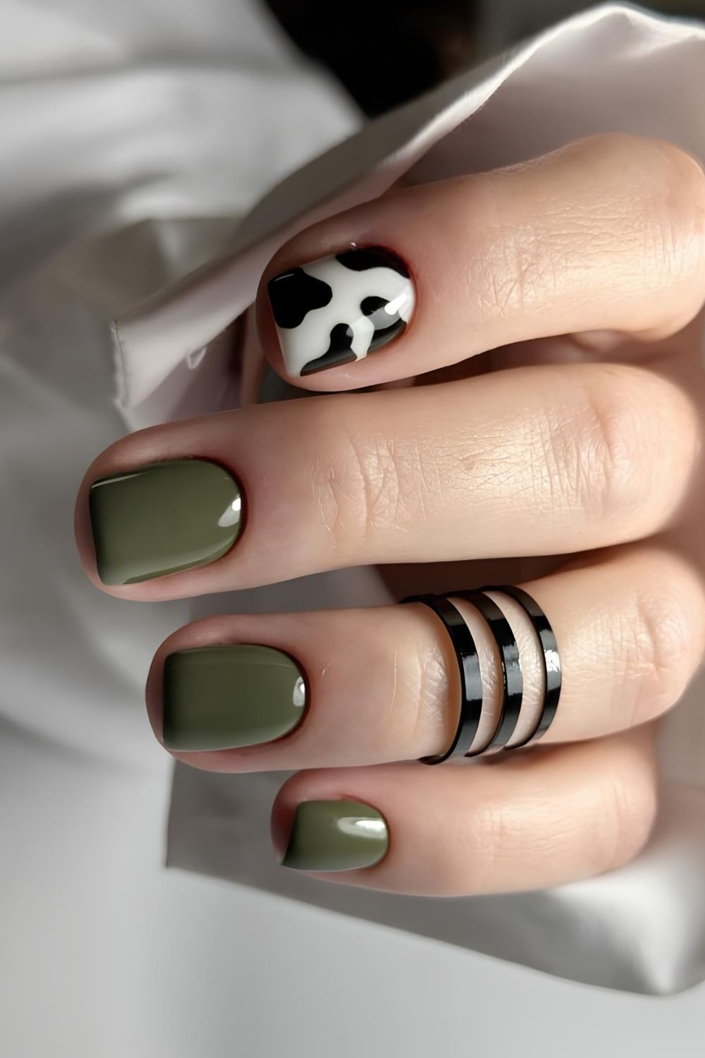 Olivgrüne Nägel mit Kuhmuster-Akzent