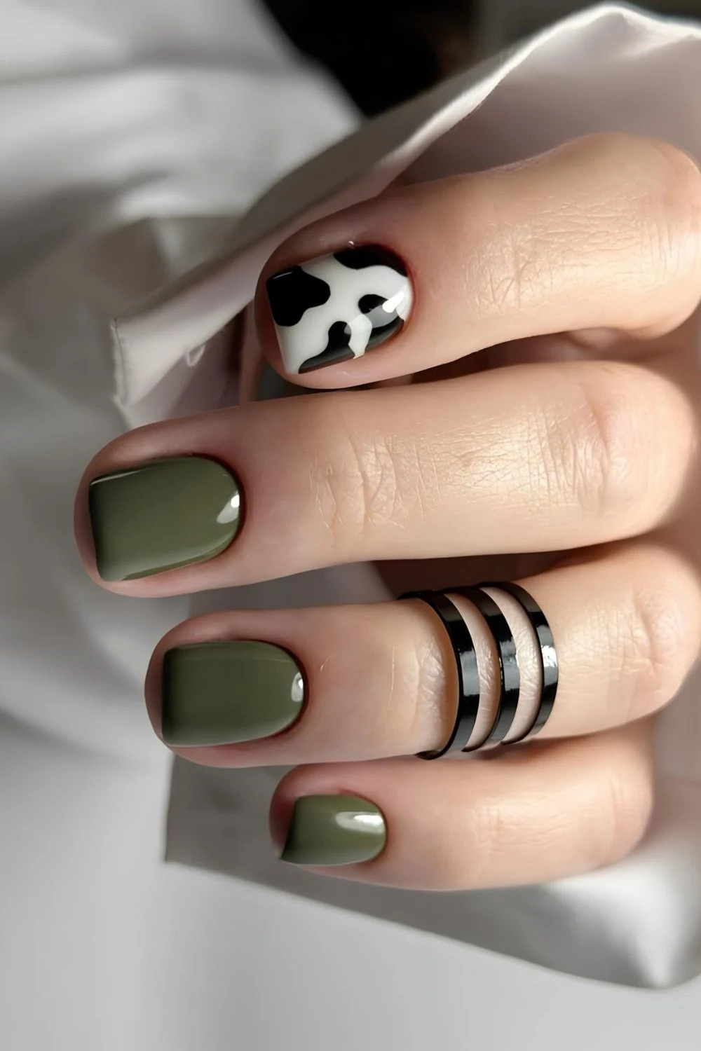 Olivgrüne Nägel mit Kuhmuster-Akzent