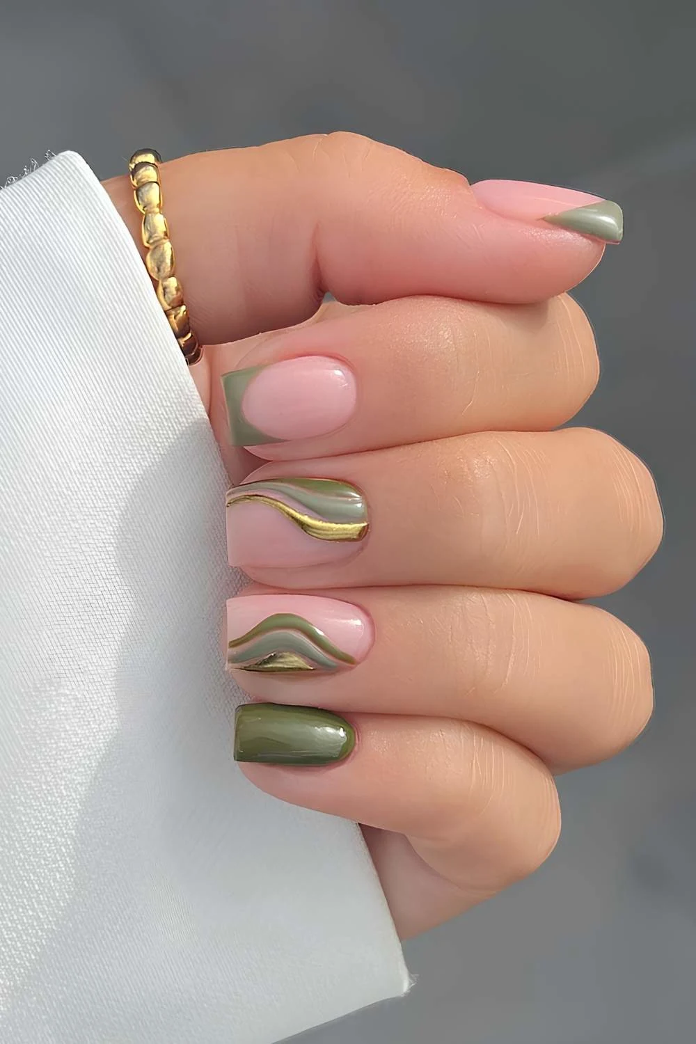 Olivgrüne Nägel mit metallischen Swirls