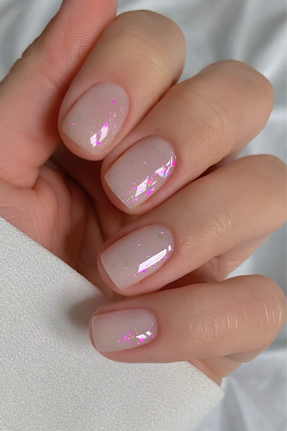 Opal inspirierte milchig weiße Nägel mit rosa Glitzerflakes