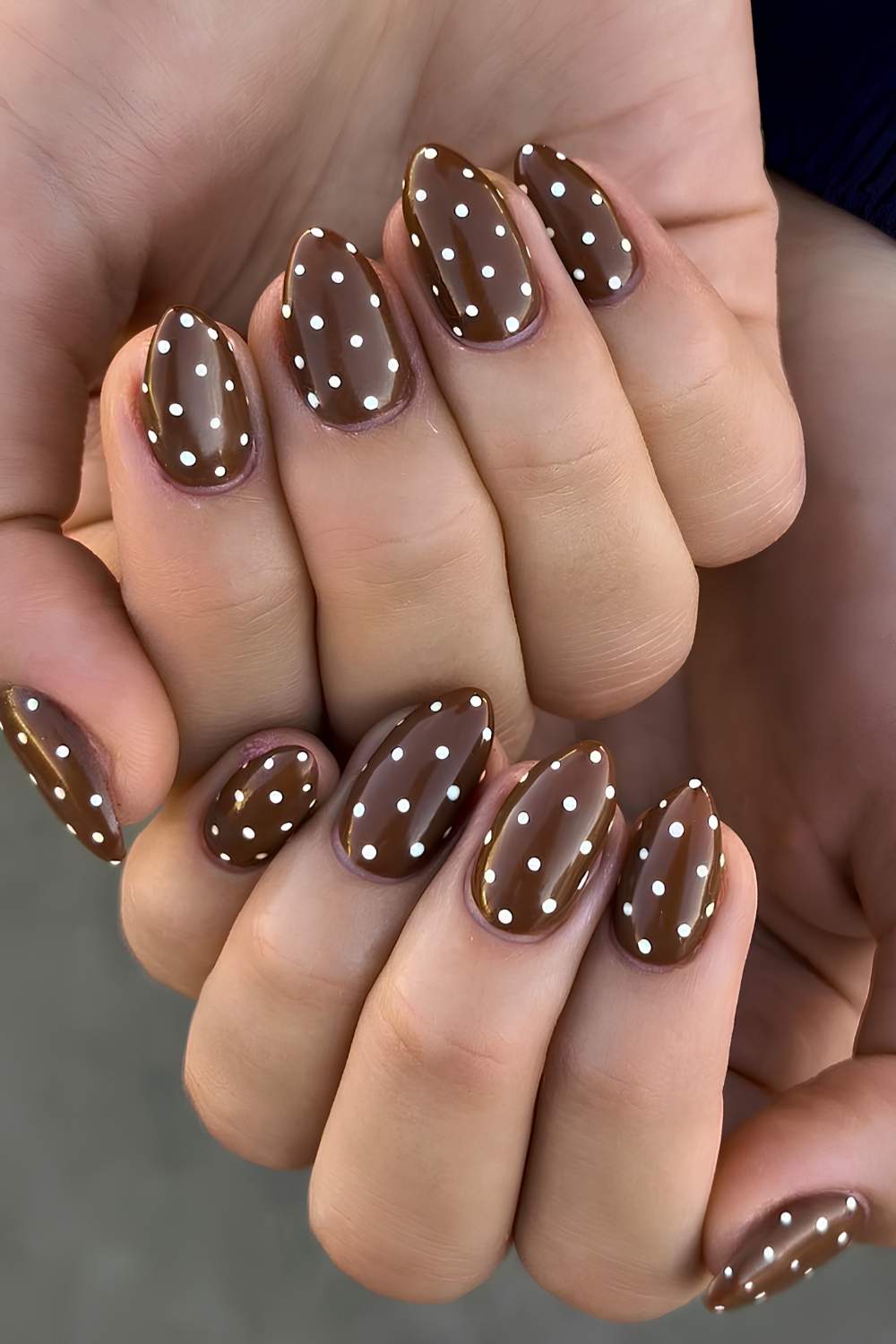 Braune Maniküre mit weißen Poka Dots