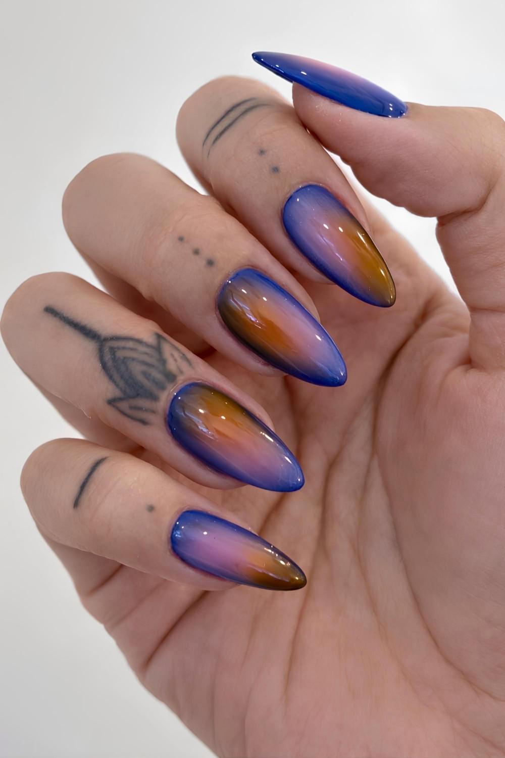 Blaue manikuere mit pinker und orangener aura
