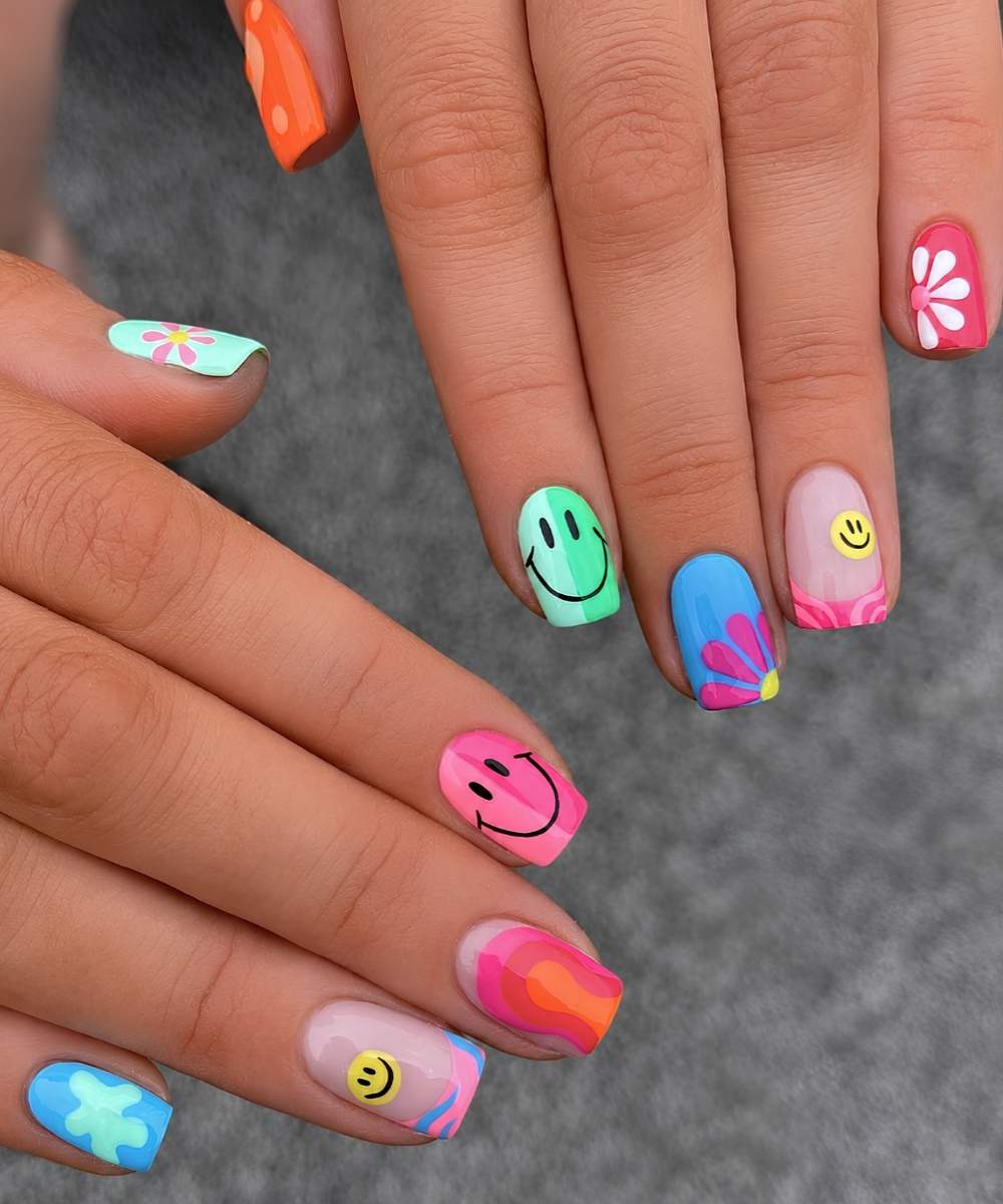Bunte kurze Naegel mit Smileys und Blumen