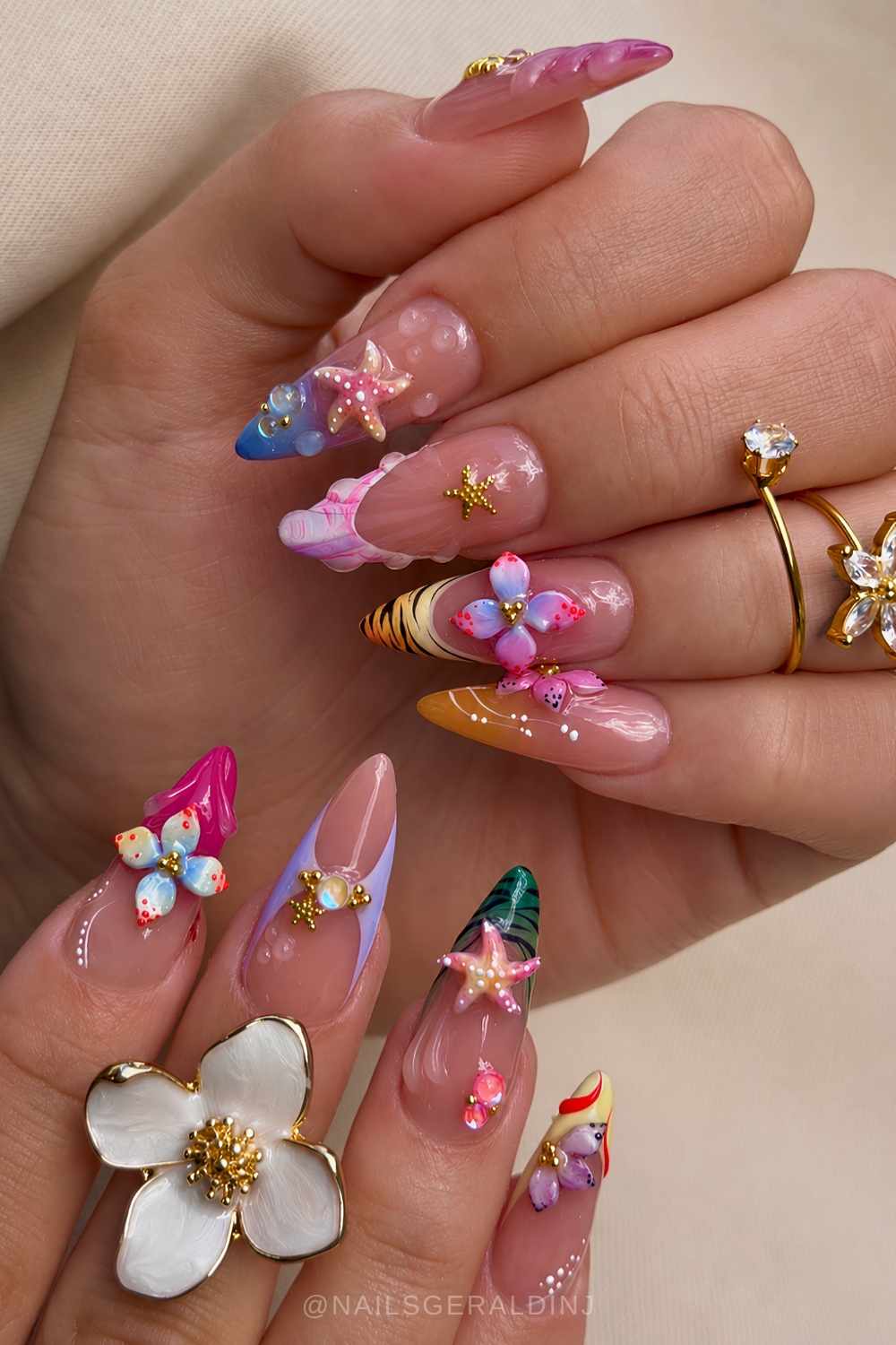 Bunte tropische Naegel mit Blumen und Seesternen