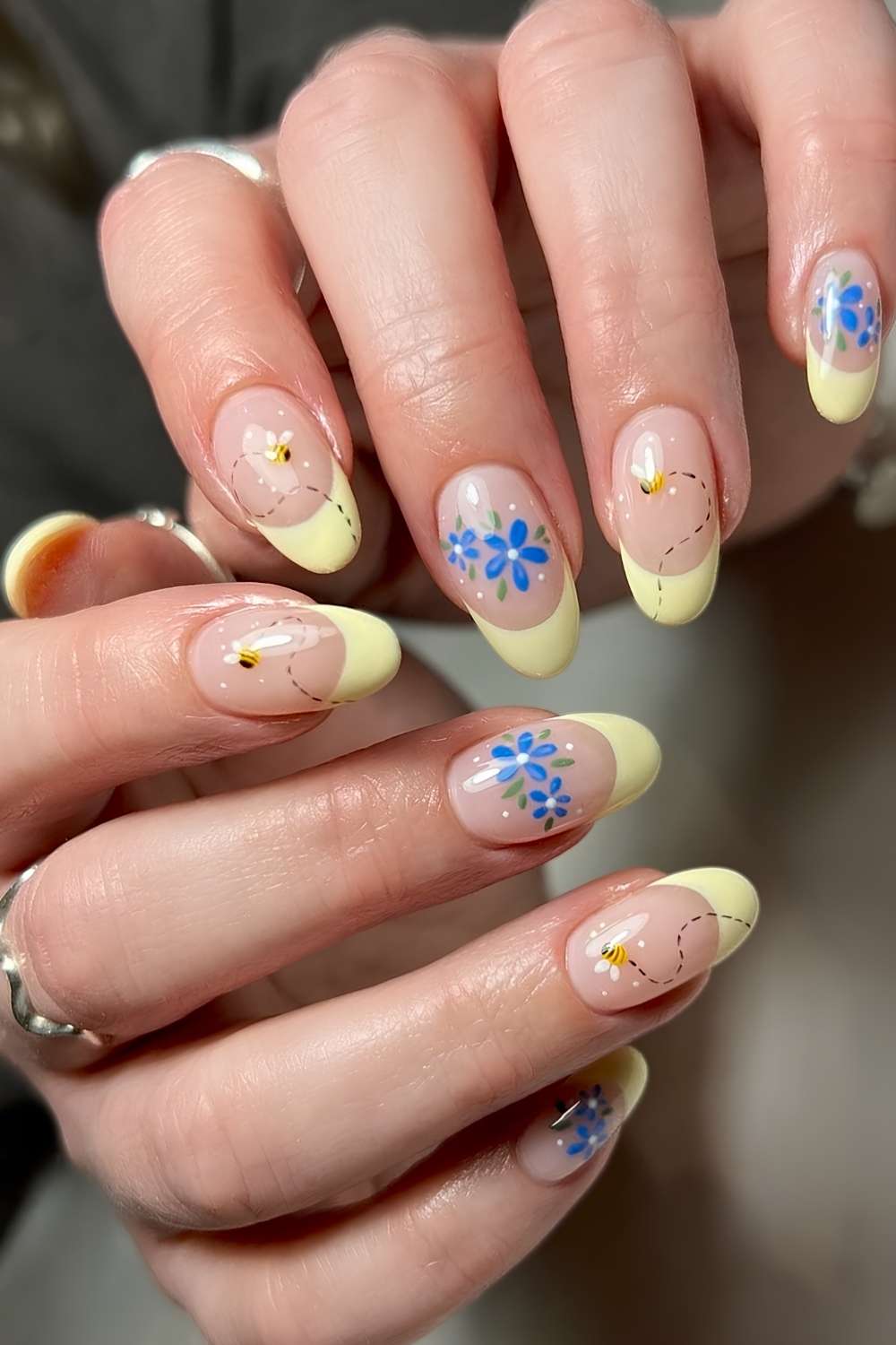 Gelbe French Mani mit Bienen und blauen Blumen