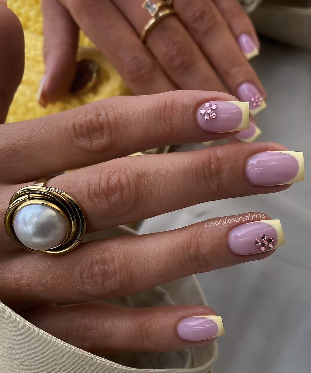 Gelbe French Naegel mit rosa Strassblumen