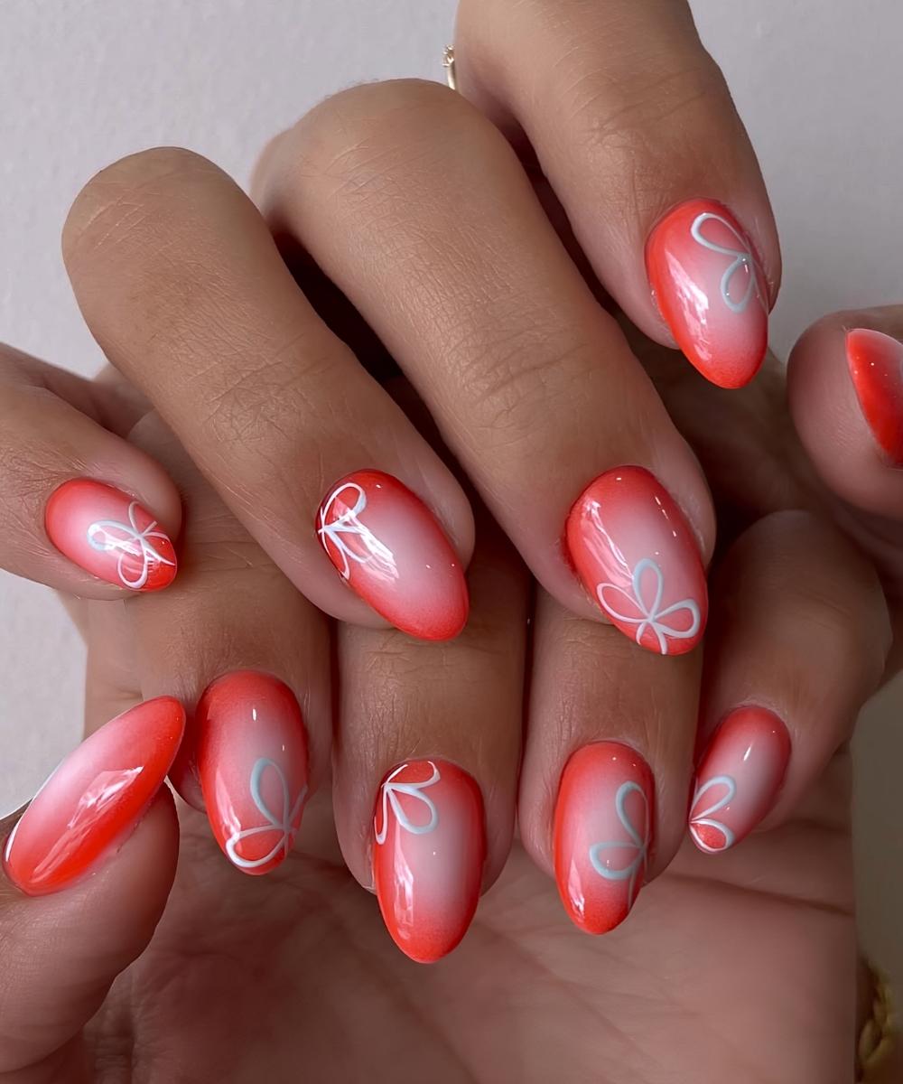 Korallrote Naegel mit Blumen Nailart