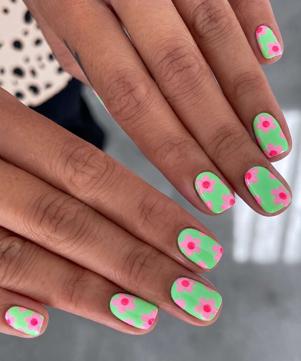 Kurze gruene Naegel mit pinken Blumen