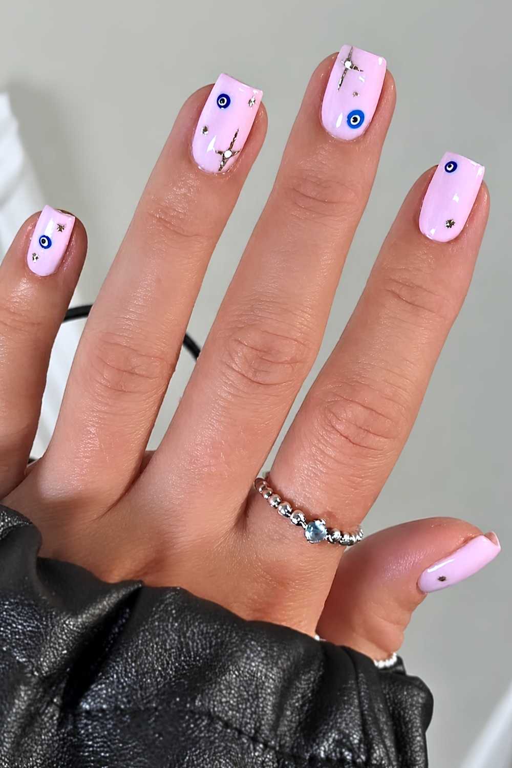 Milchig rosa Naegel mit Evil Eye Motiv