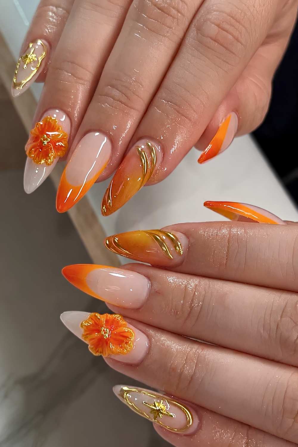 Orange Naegel mit Gold und Blumen