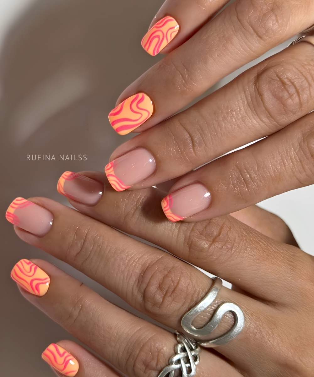 Orange Naegel mit pinken Swirls