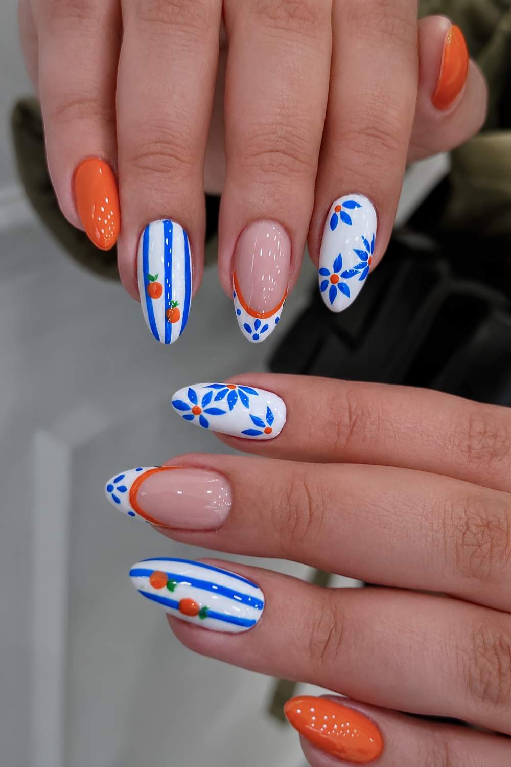 Orange blaue Naegel mit Streifen und Fruechten