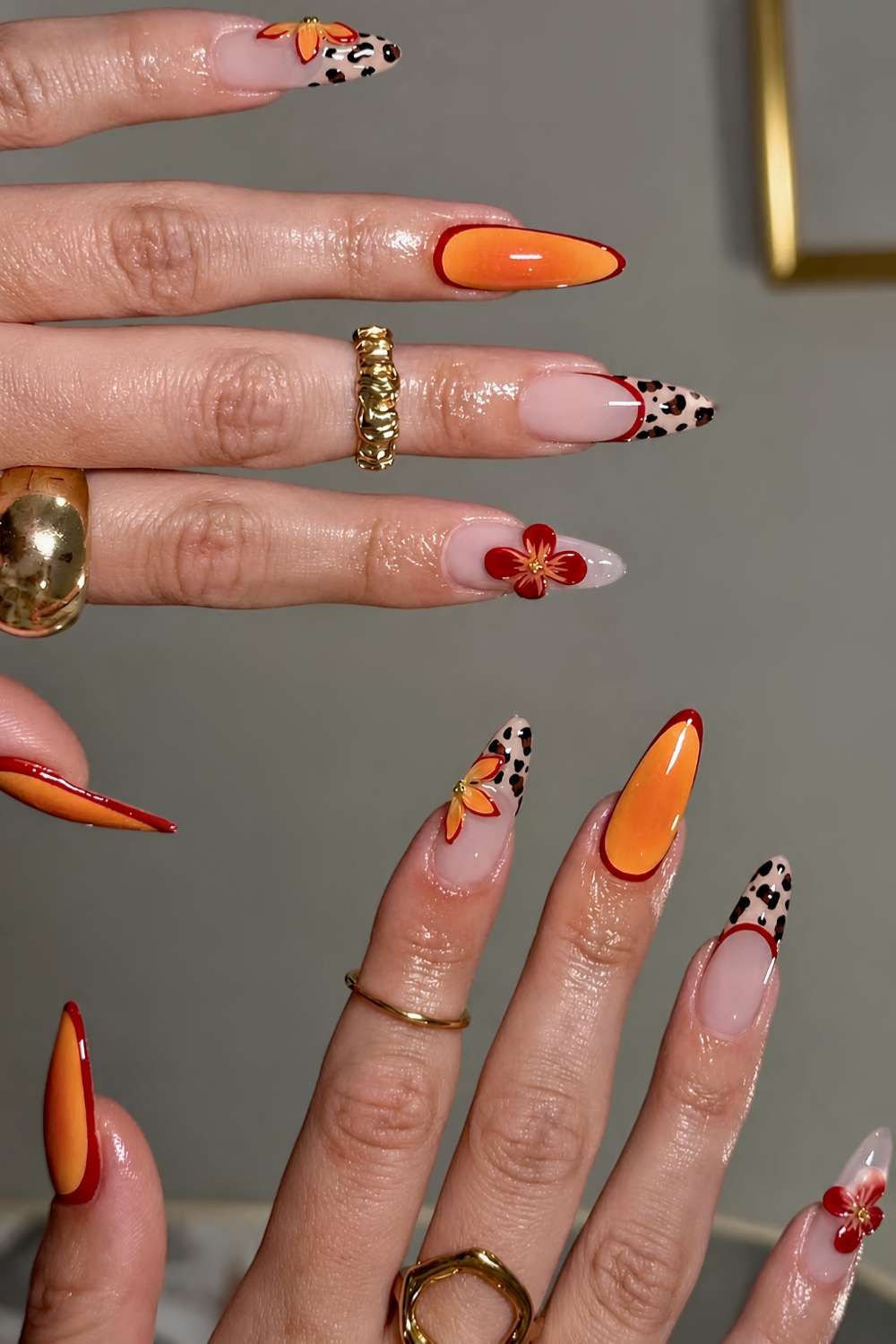 Orange rote Naegel mit Leopardenmuster