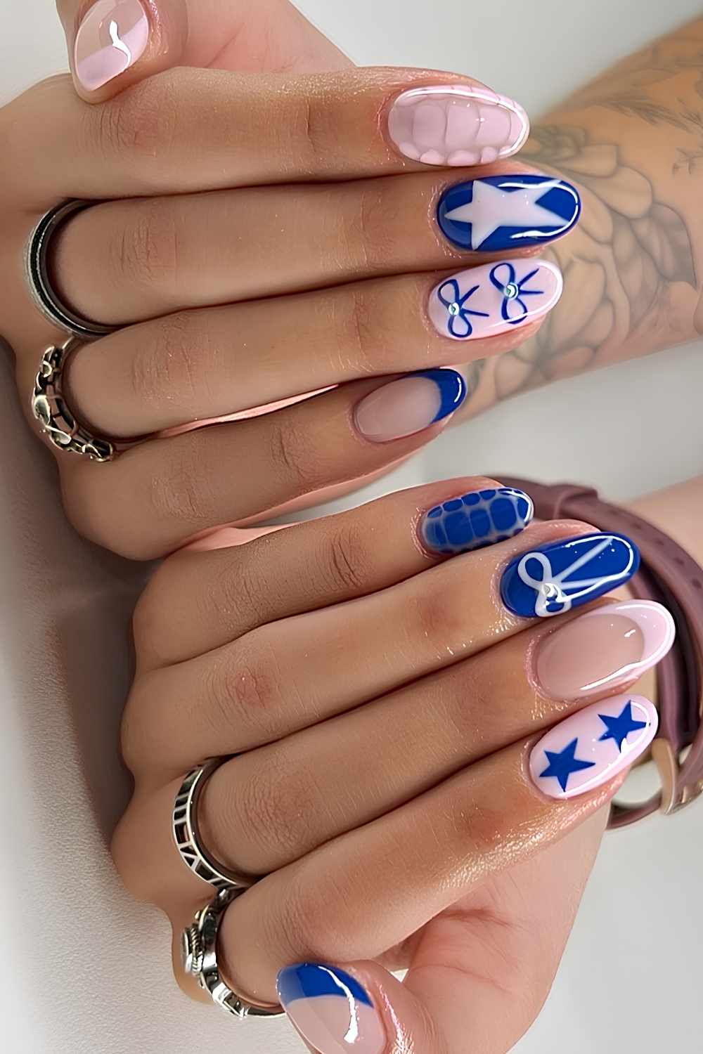 Rosa und blaue Naegel mit Sternen und Schleifen
