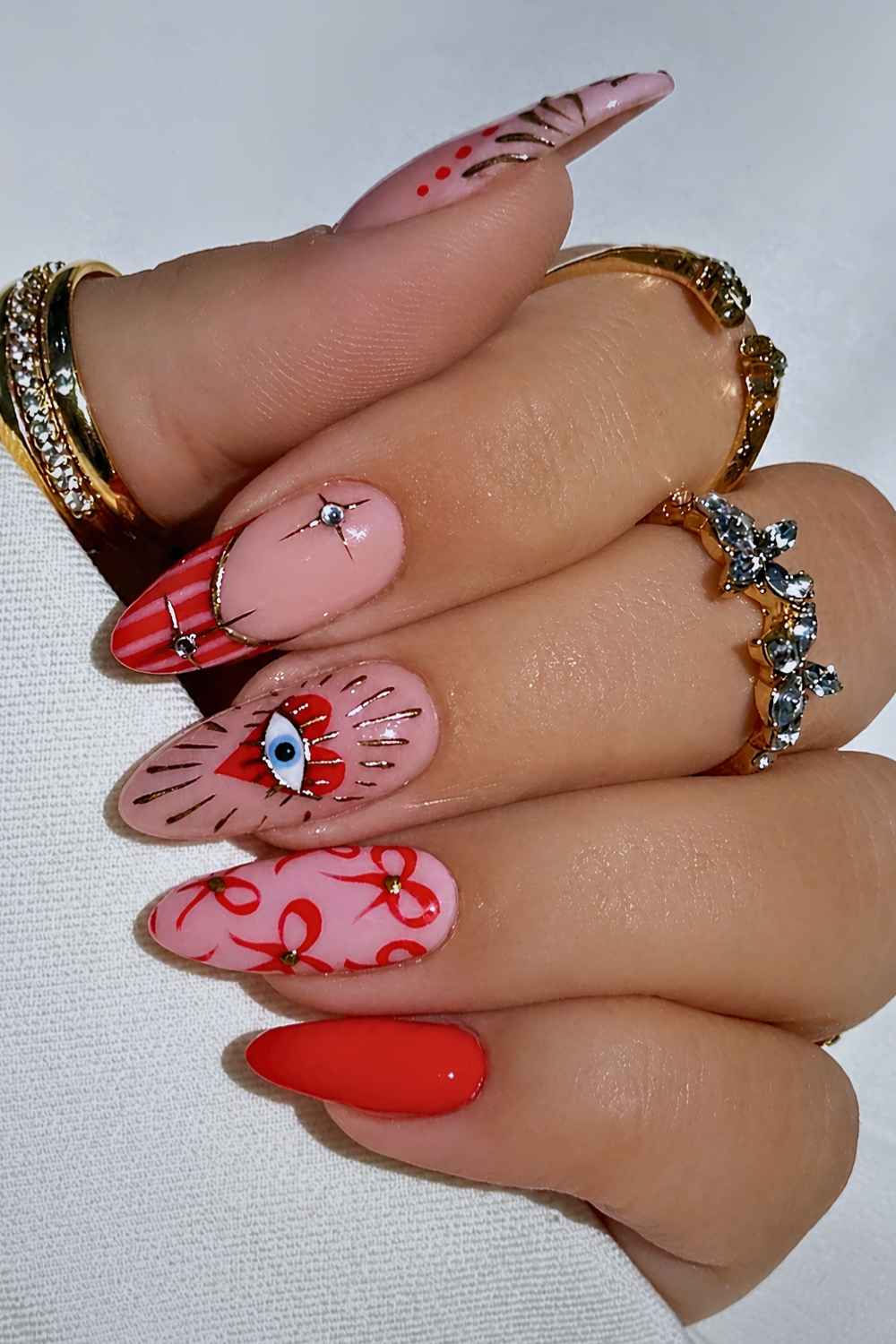 Rote Naegel mit Schleifen und Evil Eye Motiv