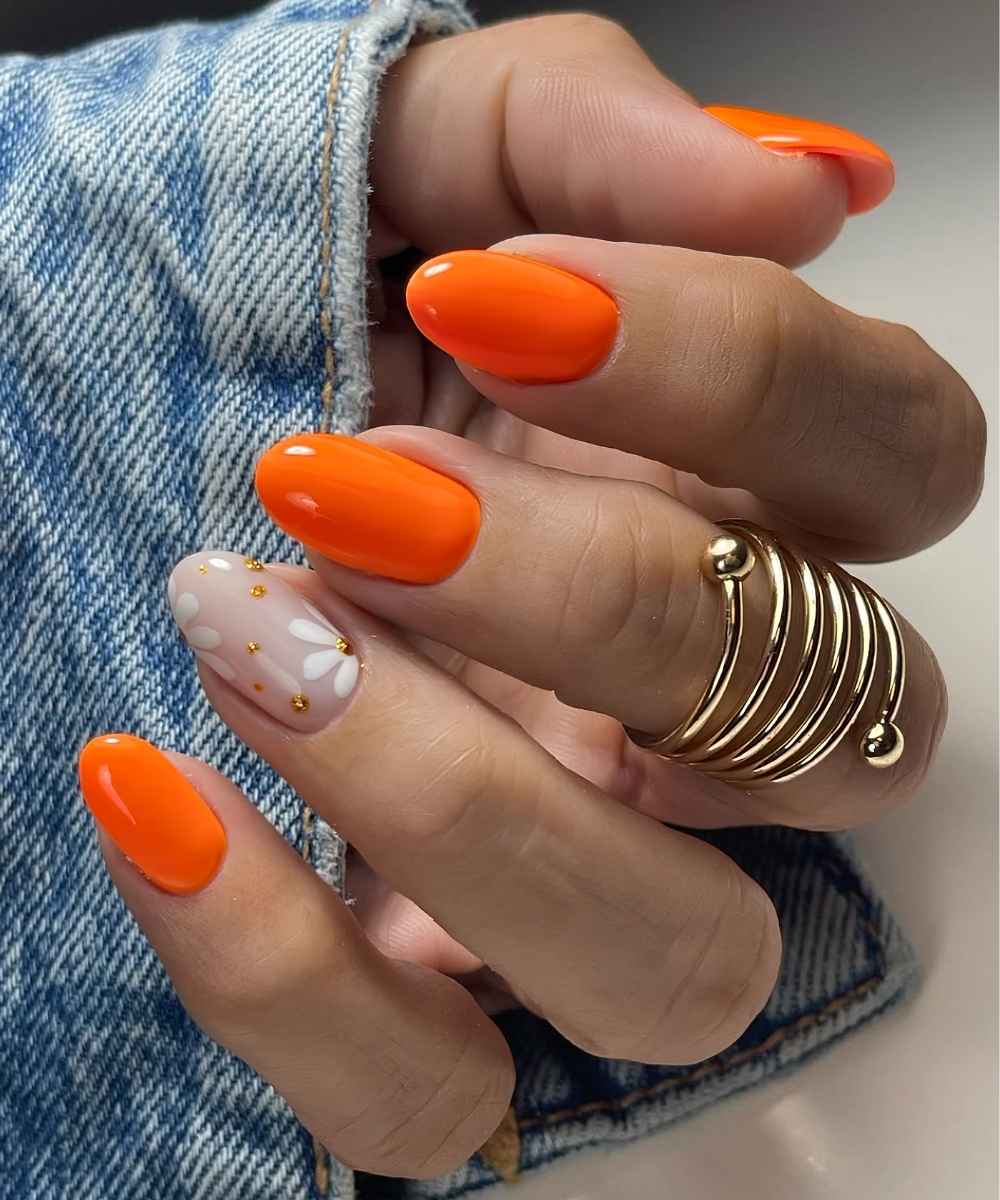 Runde orange Naegel mit Blumen