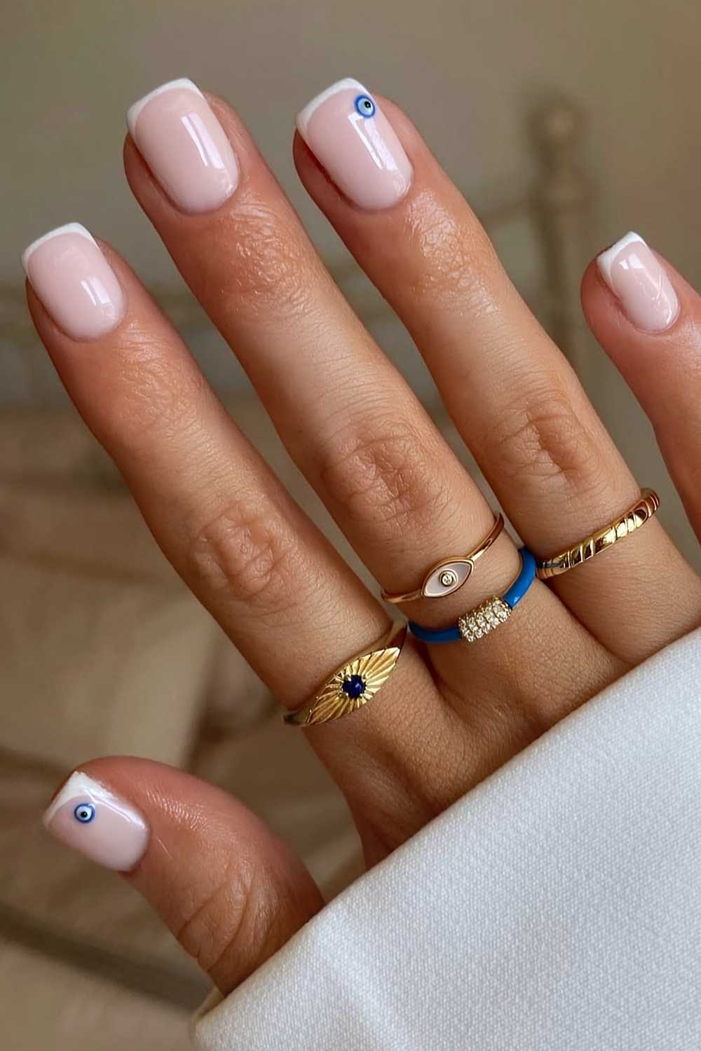 Weisse Micro French Tips mit Evil Eye Akzent