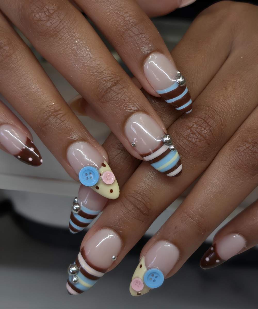 Blaue braune und gelbe Naegel mit Streifen und Knoepfen