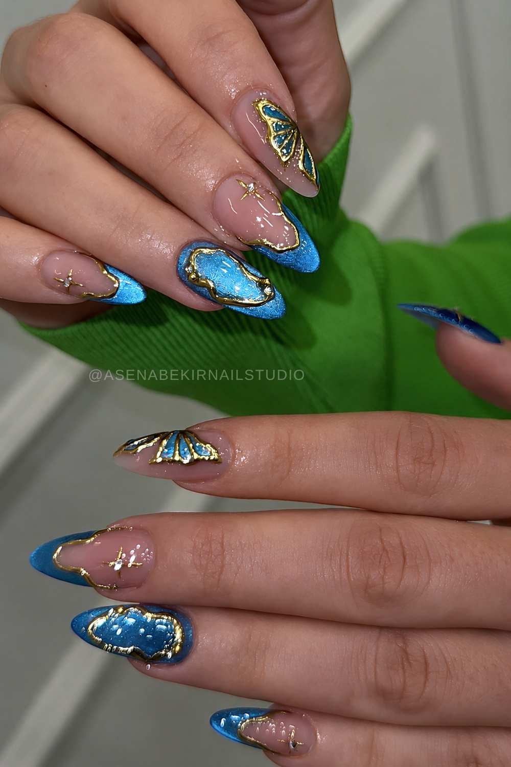 Blaue cat eye naegel mit gold und schmetterling