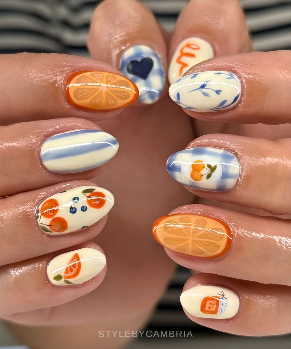 Blaue und vanillefarbene picknick naegel mit orangenmotiven