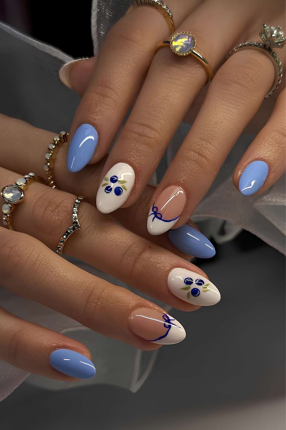 Blaue und weisse Manikuere mit Blaubeeren und Schleifen