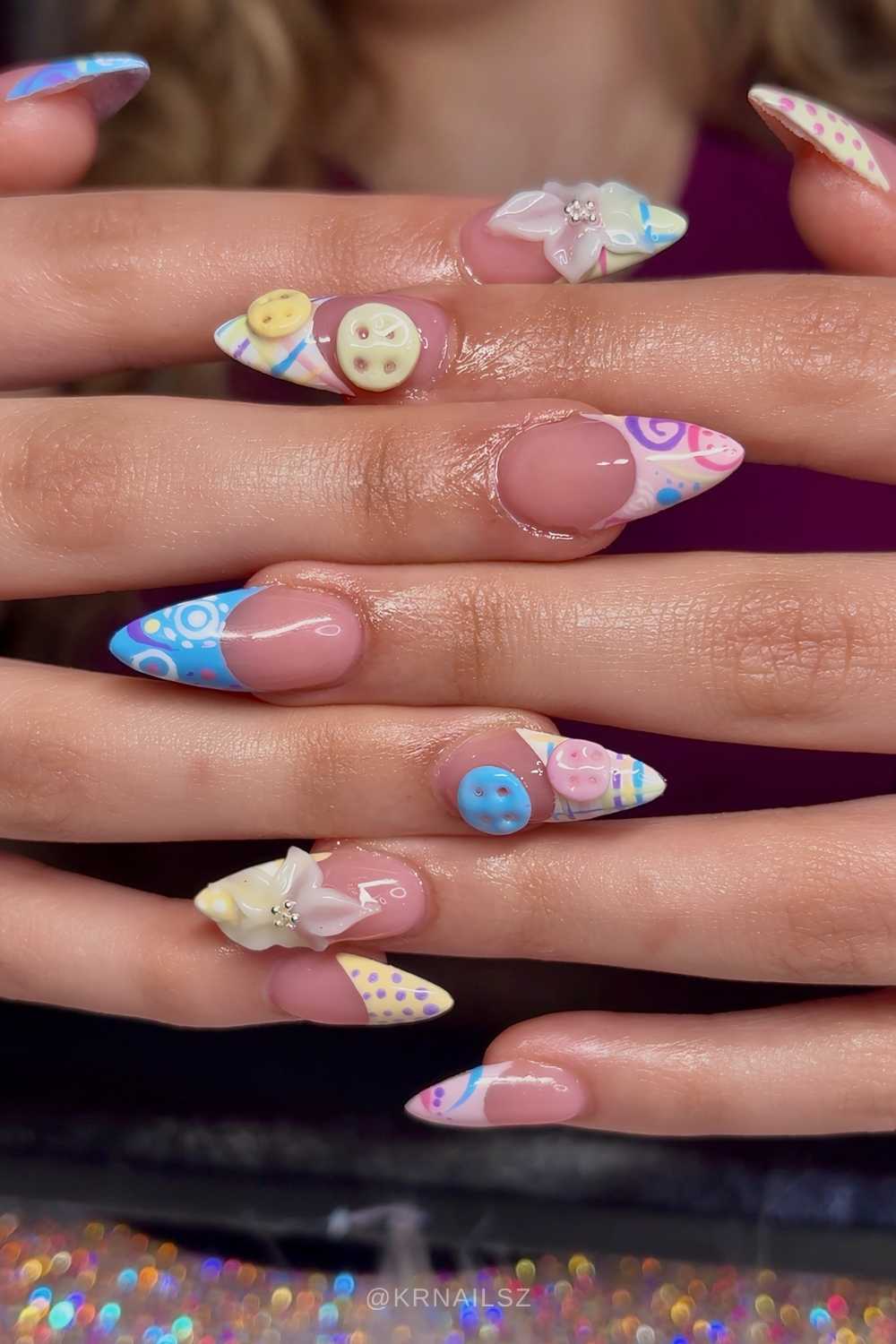 Gemusterte Pastell French Naegel mit Knopfdesign