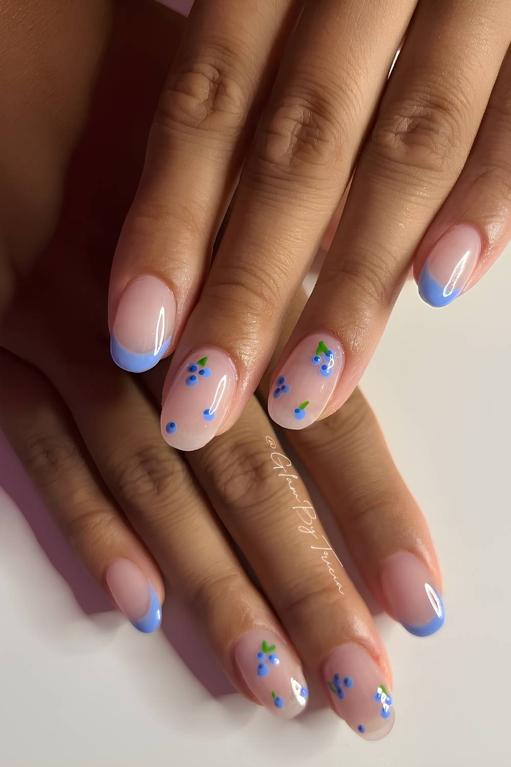 Glaenzende blaue French Manikuere mit Blaubeeren