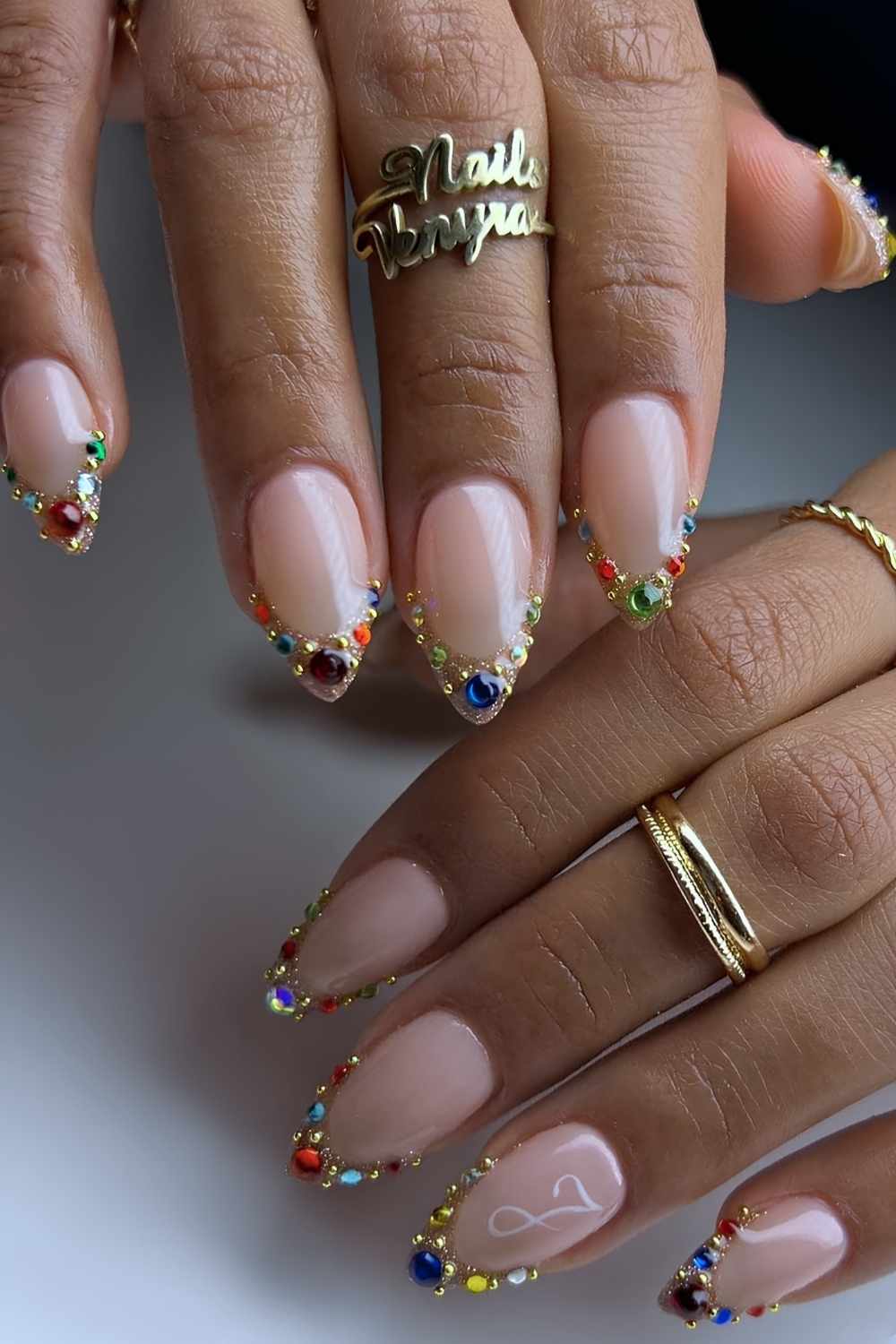 Goldene French Nagel mit bunten Schmucksteinen