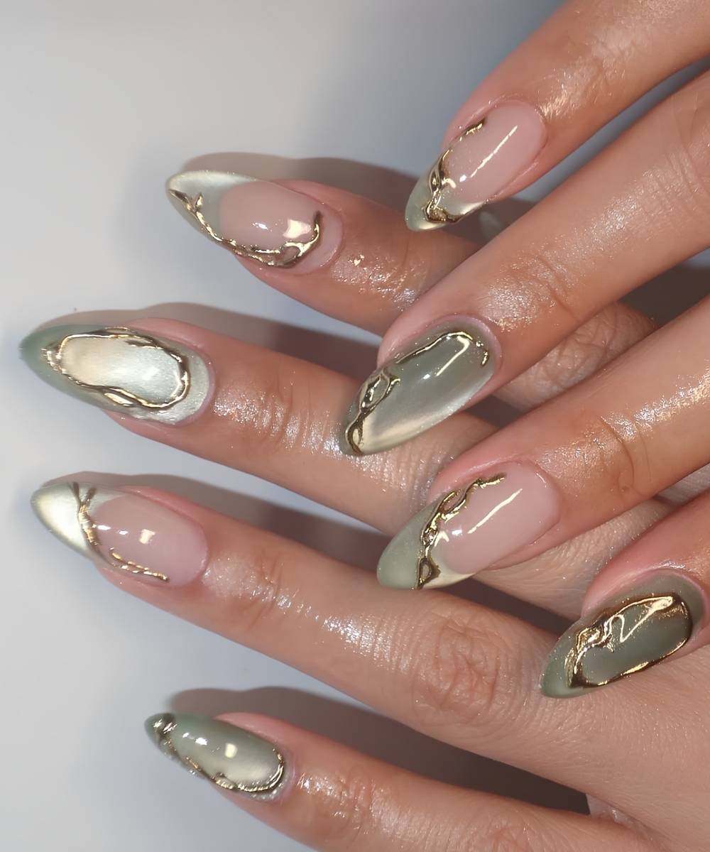 Jadegruene Cat Eye Naegel mit Goldakzenten