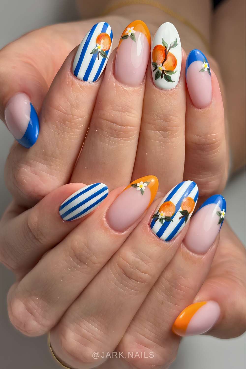 Koenigsblaue und orange naegel mit streifen und zitrusmotiven