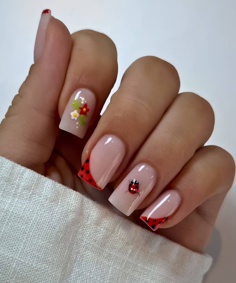 Milchige Naegel mit Blumen und Marienkaefern